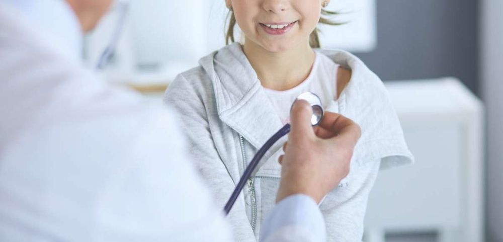 Kind sitzt still während Doktor sie untersucht