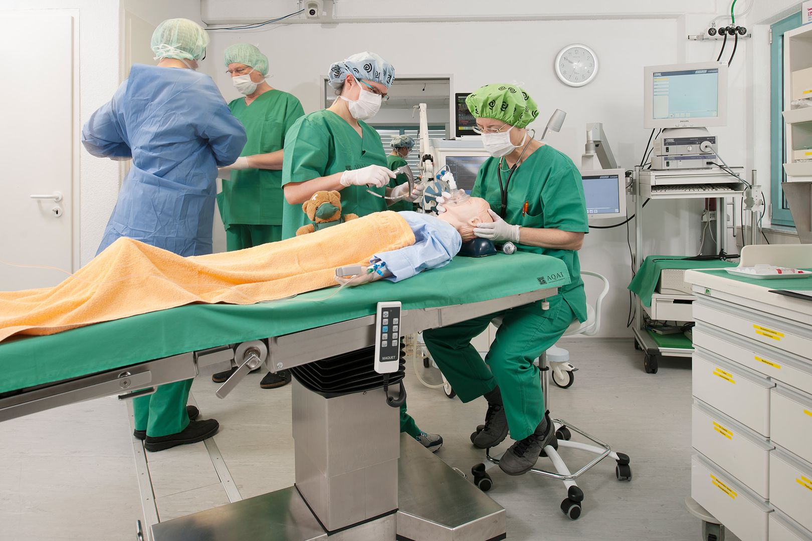 Puppe auf einem OP-Tisch mit Ärzten die eine OP simulieren